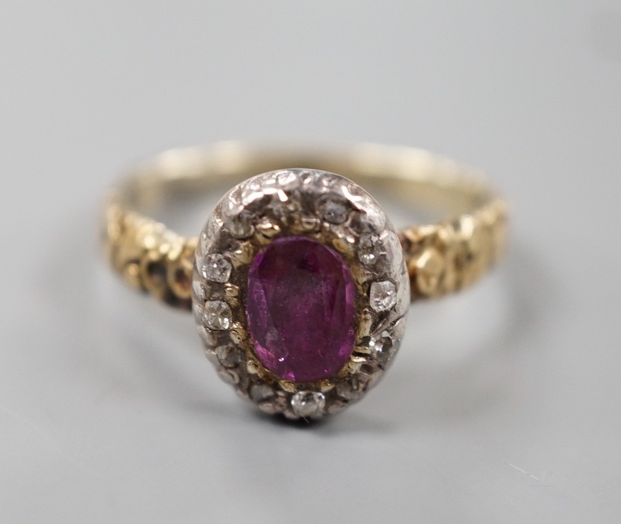 A 19th century yellow metal, garnet and diamond set oval cluster ring, size M, gross weight 2.2 grams.